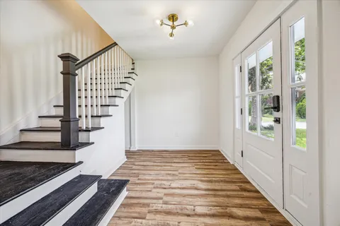 a view of a hallway with wooden floor and staircase