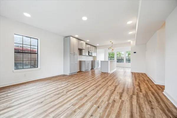 a view of empty room with wooden floor and windows