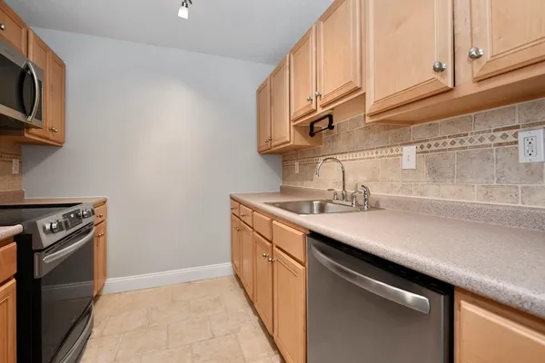 a kitchen with a sink cabinets and stainless steel appliances