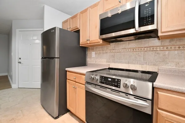 a kitchen with stainless steel appliances a refrigerator stove and microwave