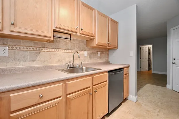 a kitchen with stainless steel appliances granite countertop a sink and a white cabinets
