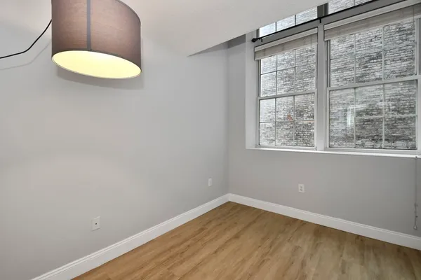 a view of a room with wooden floor and a window