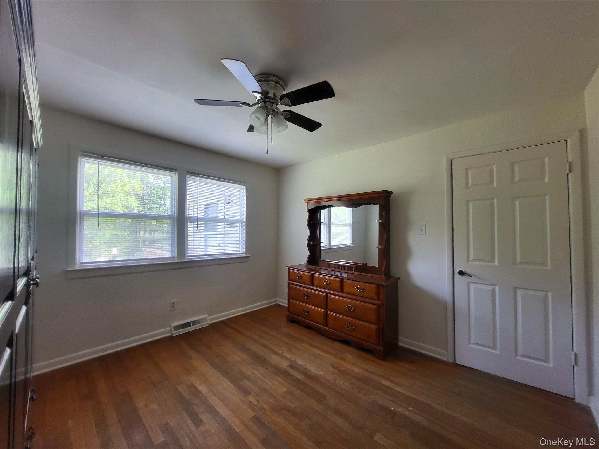 286 Dingle Daisy Road Monticello, NY 12701 - Photo 24 of 35 a view of a livingroom with wooden floor a ceiling fan and windows