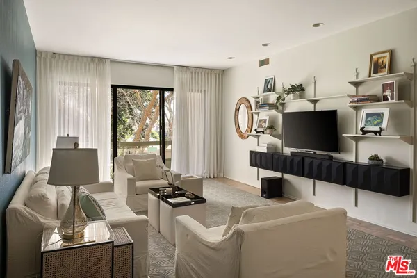 a living room with furniture a flat screen tv and a large window