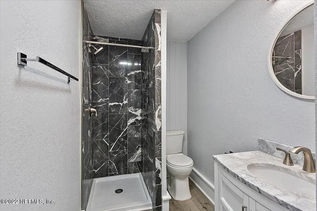 a bathroom with a shower a toilet and a sink