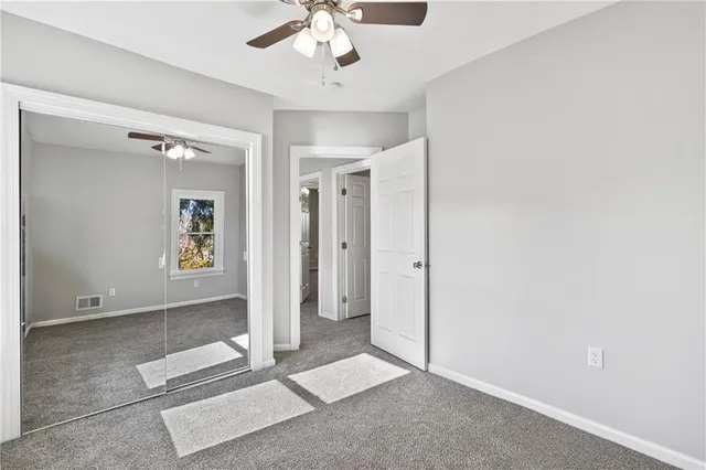 an empty room with fan and entrance