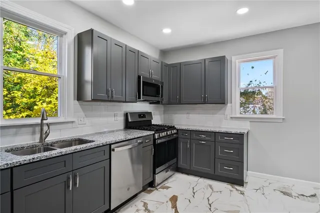 a kitchen with stainless steel appliances granite countertop a sink stove and microwave