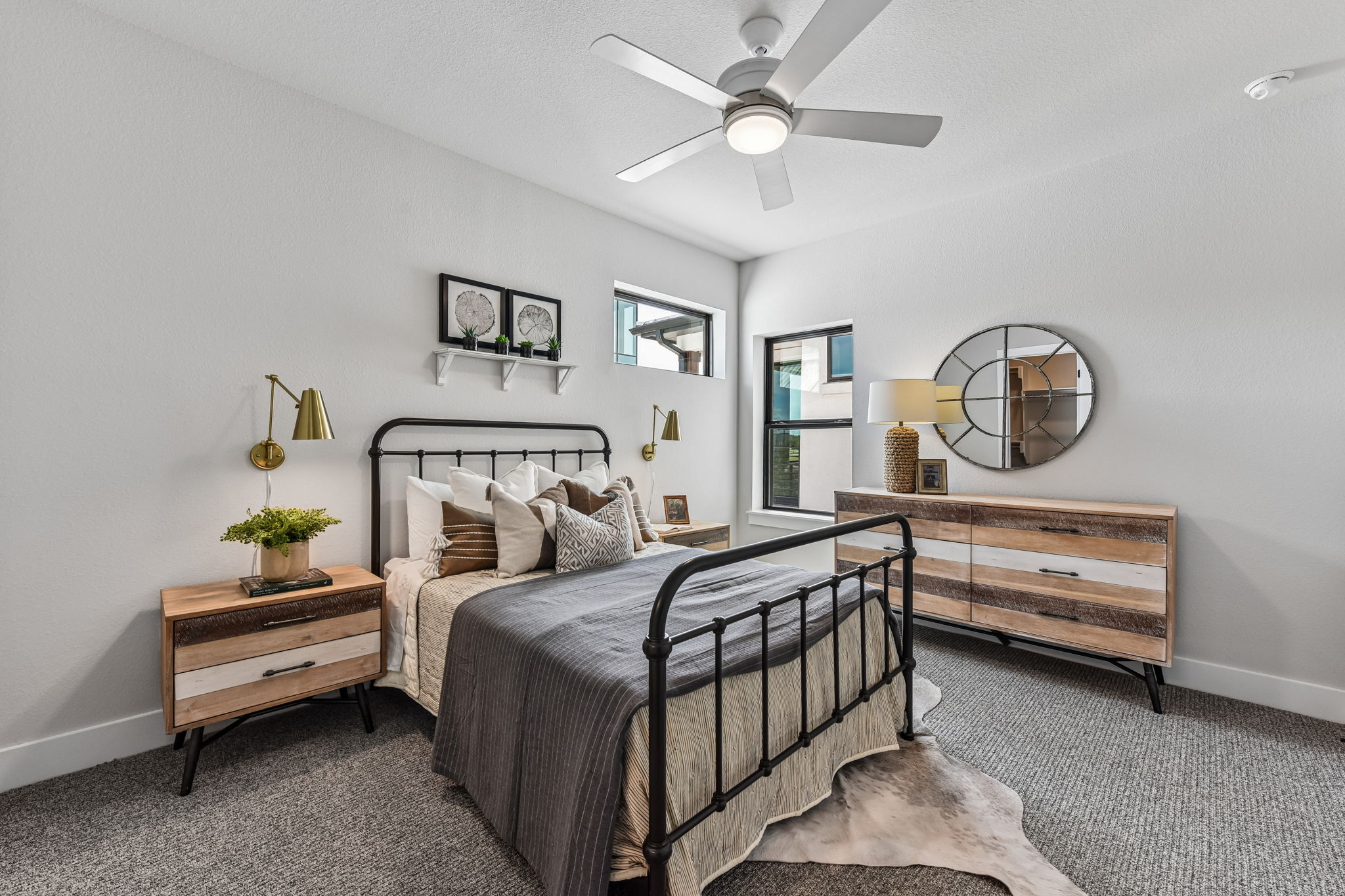 9101 Cattle Baron Path Austin, TX 78747 - Photo 27 of 40 A well-lit bedroom features a sleek ceiling fan and contemporary windows.