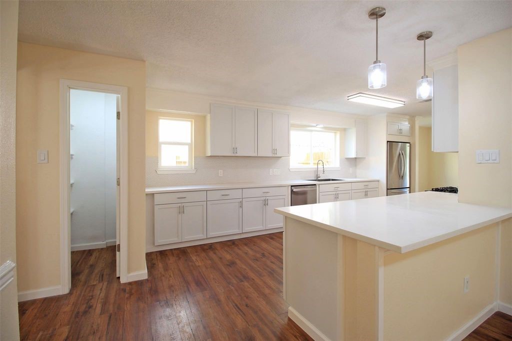 8011 Goldengrove Drive Spring, TX 77379 - Photo 13 of 48 a kitchen with a sink a stove cabinets and wooden floor