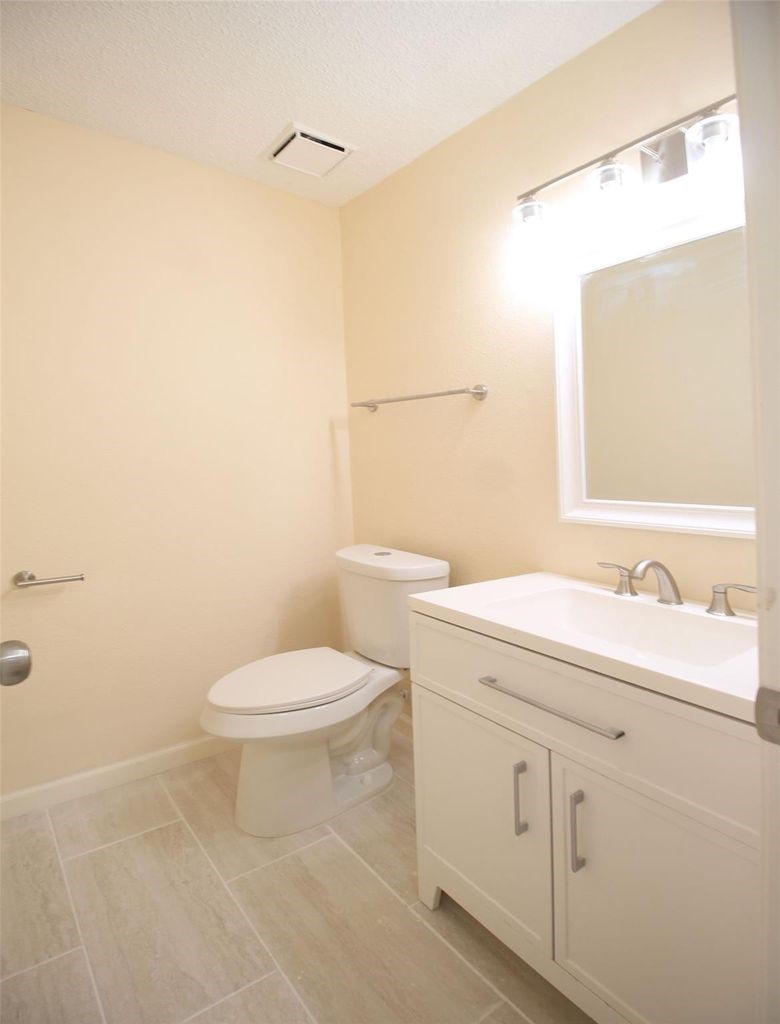 8011 Goldengrove Drive Spring, TX 77379 - Photo 21 of 48 a bathroom with a toilet a sink a vanity and mirror
