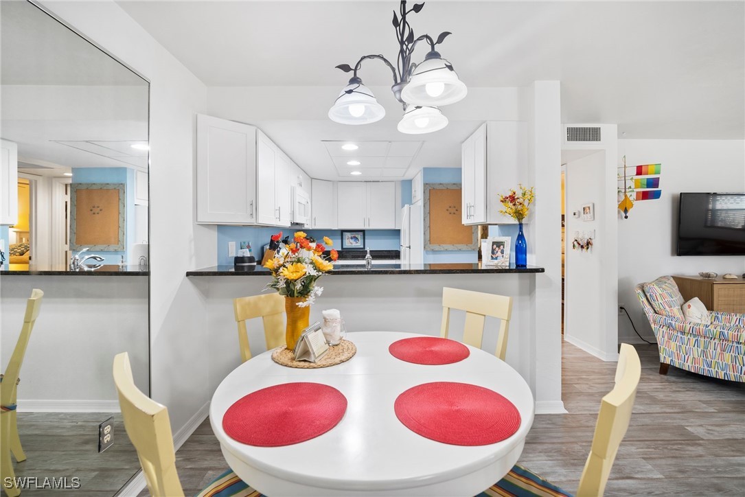 13241 Whitehaven Lane, Unit 803 Fort Myers, FL 33966 - Photo 11 of 22 a kitchen with stainless steel appliances granite countertop a dining table and chairs