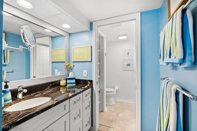 a spacious bathroom with a granite countertop sink and a mirror