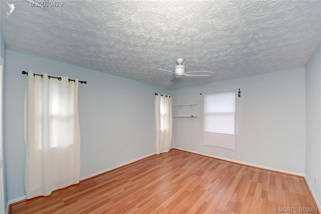 2126 Southeast Dolphin Road Port St. Lucie, FL 34952 - Photo 24 of 30 a view of empty room with wooden floor and fan