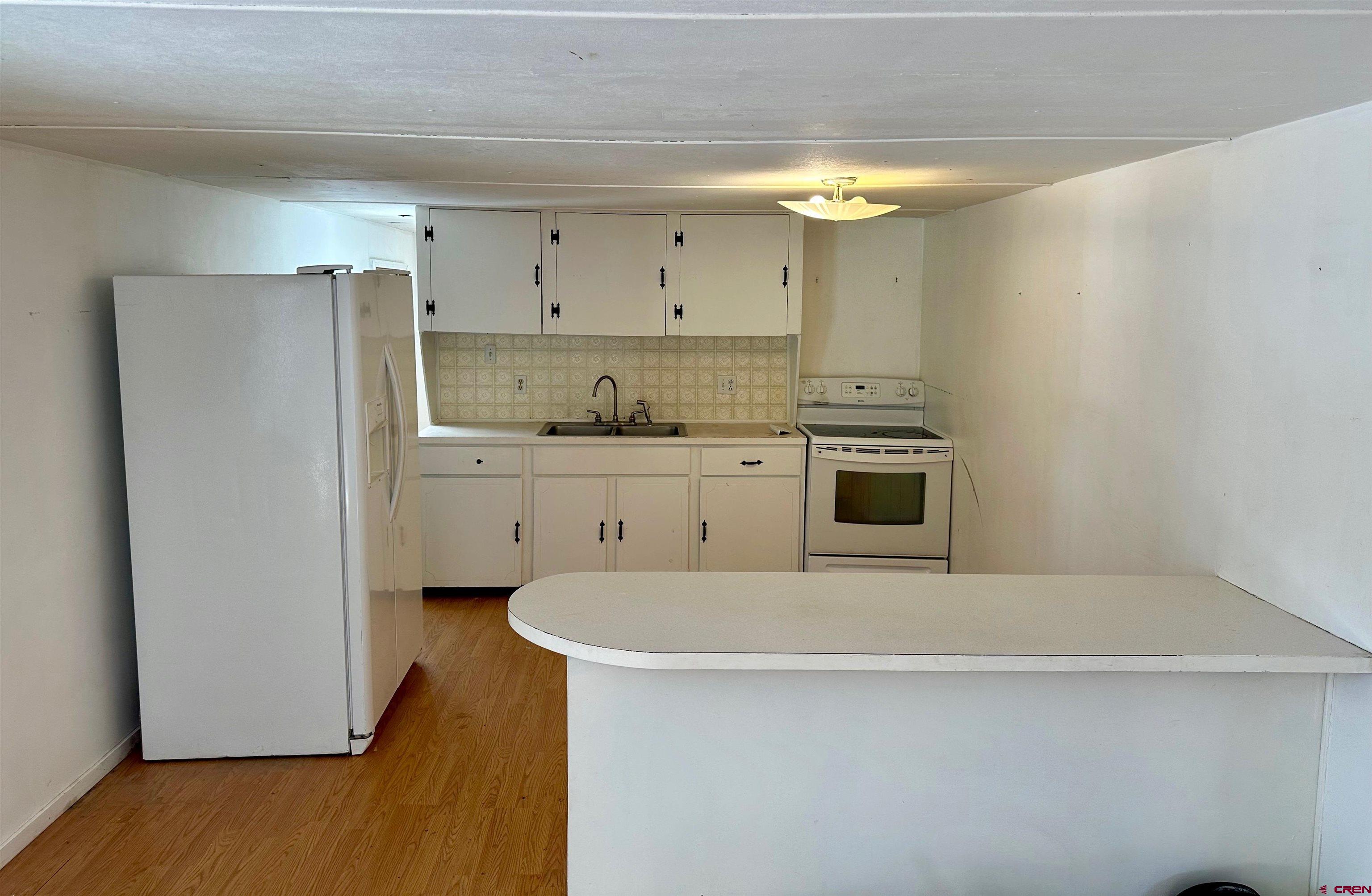 41559 Road H 25 Mancos Co 81328 Mancos, CO 81328 - Photo 3 of 20 a kitchen with stainless steel appliances a refrigerator a sink a stove and white cabinets