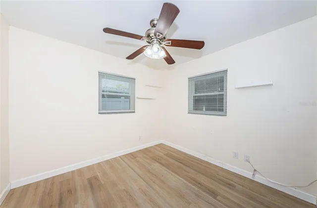 a view of empty room with wooden floor