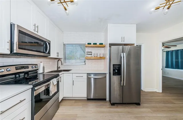 a kitchen with stainless steel appliances a refrigerator stove and microwave