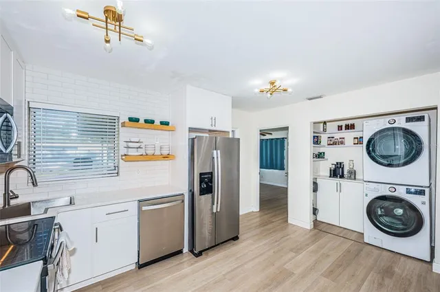 a kitchen with a refrigerator and washer dryer