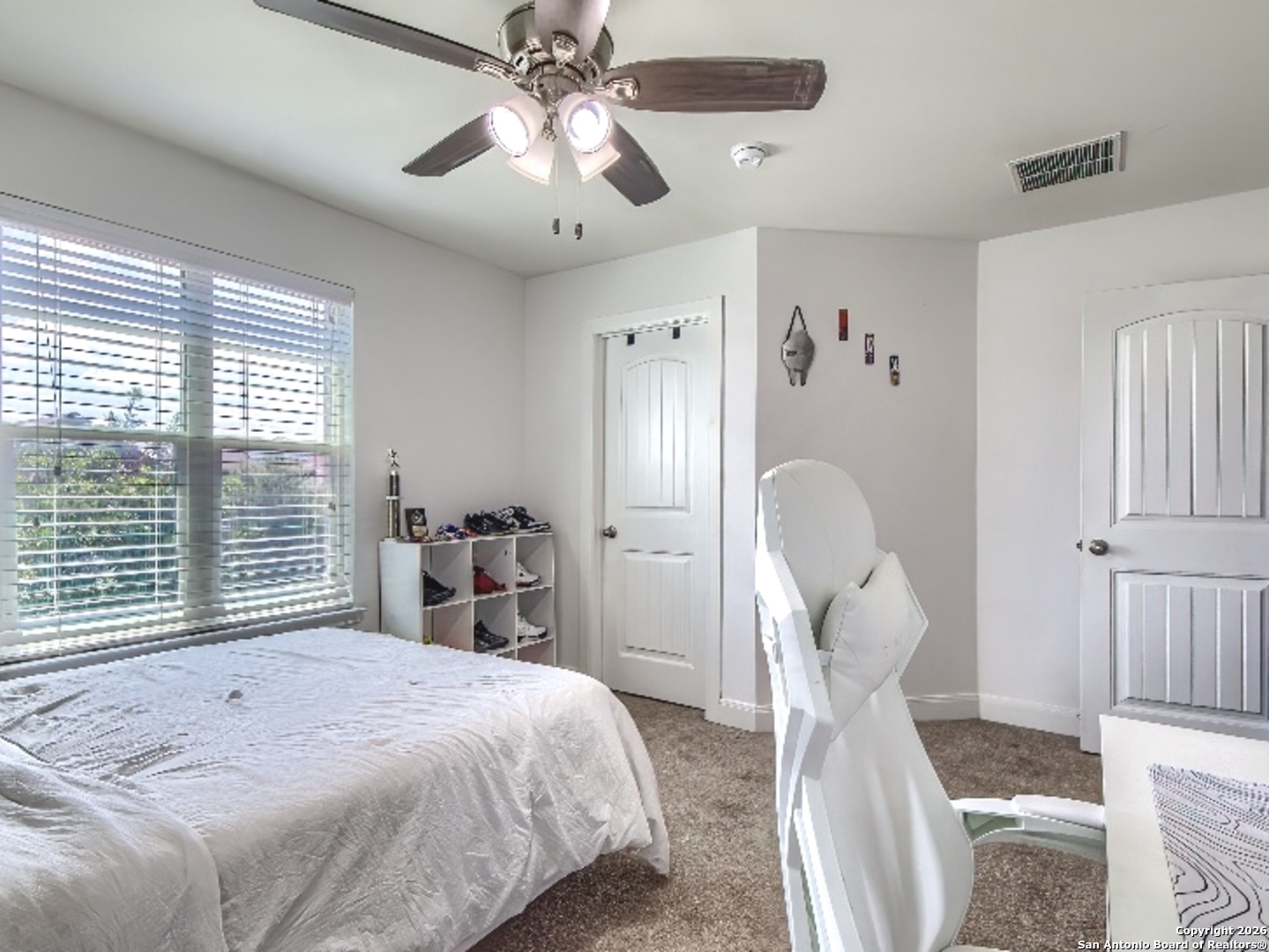 7566 Copper Cove Converse, TX 78109 - Photo 17 of 22 a bedroom with a large bed and a chandelier