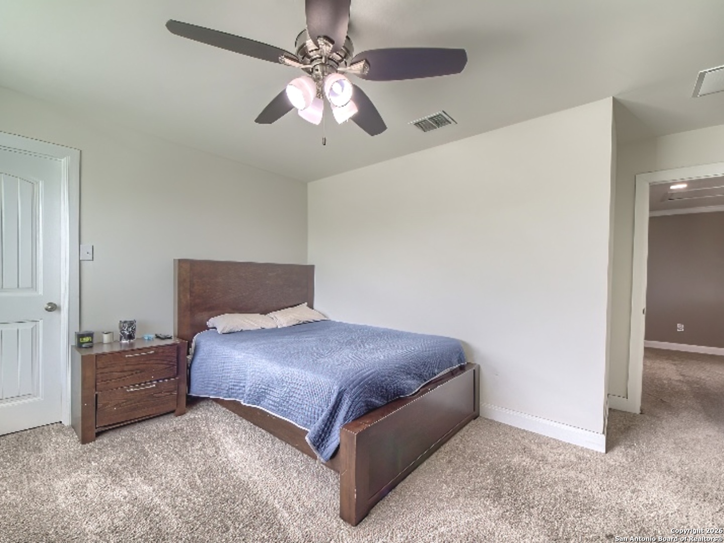 7566 Copper Cove Converse, TX 78109 - Photo 19 of 22 a spacious bedroom with a bed and a chandelier
