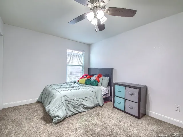 a bedroom with a bed and a chandelier fan