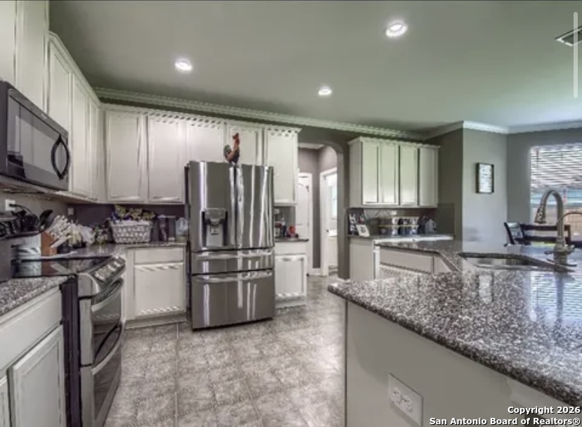 7566 Copper Cove Converse, TX 78109 - Photo 8 of 22 a kitchen with refrigerator cabinets and stainless steel appliances