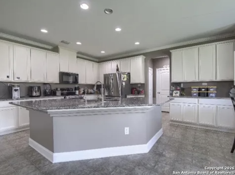 7566 Copper Cove Converse, TX 78109 - Photo 9 of 22 a large kitchen with stainless steel appliances granite countertop a stove a sink a refrigerator and white cabinets