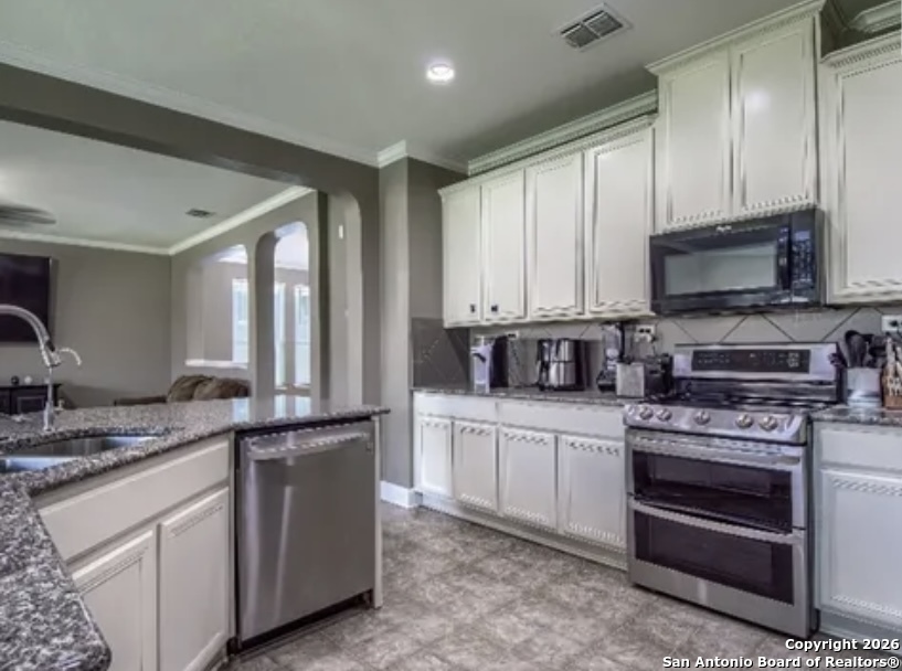 7566 Copper Cove Converse, TX 78109 - Photo 10 of 22 a kitchen with stainless steel appliances granite countertop a stove a sink and a microwave