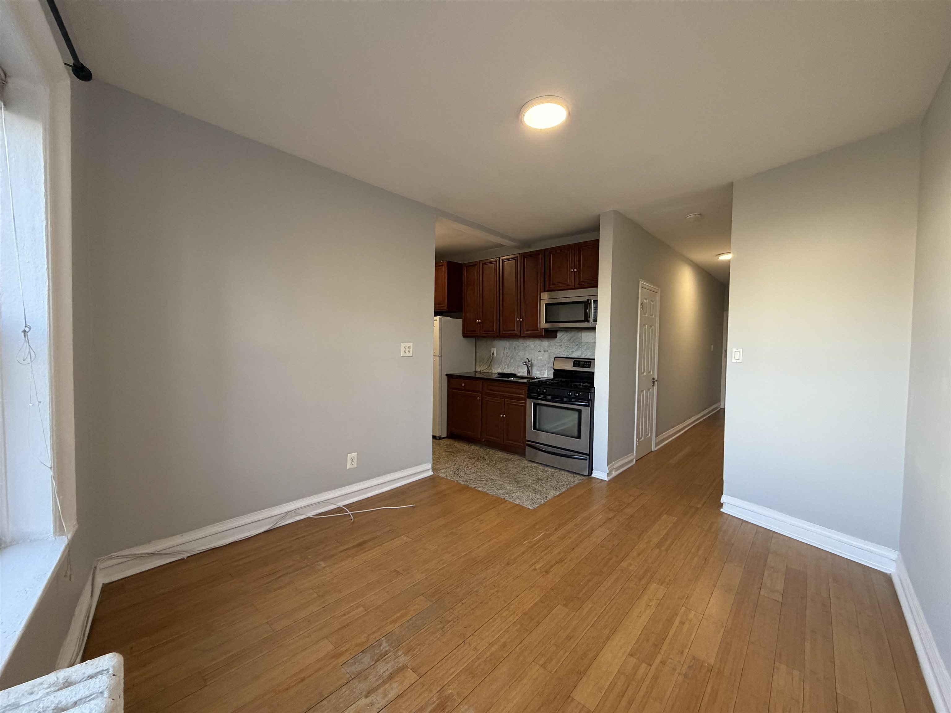 57 Corbin Avenue, Unit 4 Jersey City, NJ 07306 - Photo 4 of 8 a kitchen with stainless steel appliances a refrigerator and a wooden floor