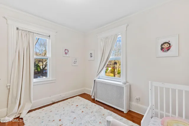 a view of a bedroom with a window and wooden floor