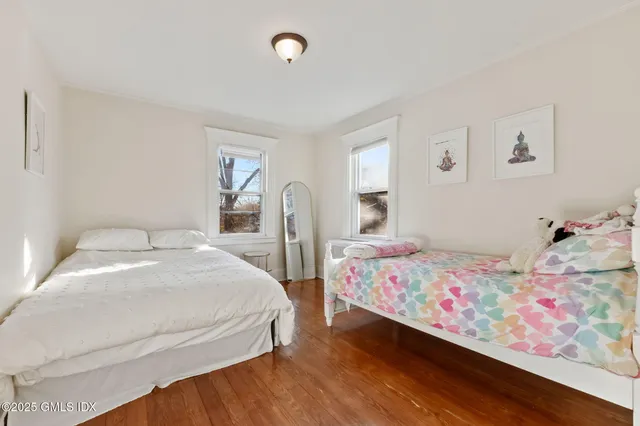 a bedroom with two beds and a painting on the wall