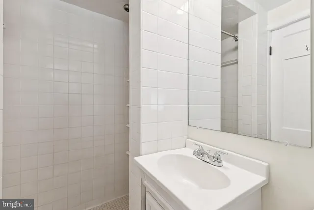 a bathroom with a sink shower and a mirror