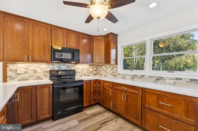 a kitchen with stainless steel appliances wooden cabinets a stove and a sink