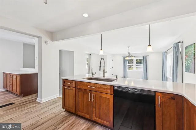 a kitchen with granite countertop a sink cabinets and wooden floor