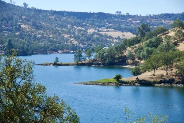 an aerial view of residential houses with outdoor space and lake view