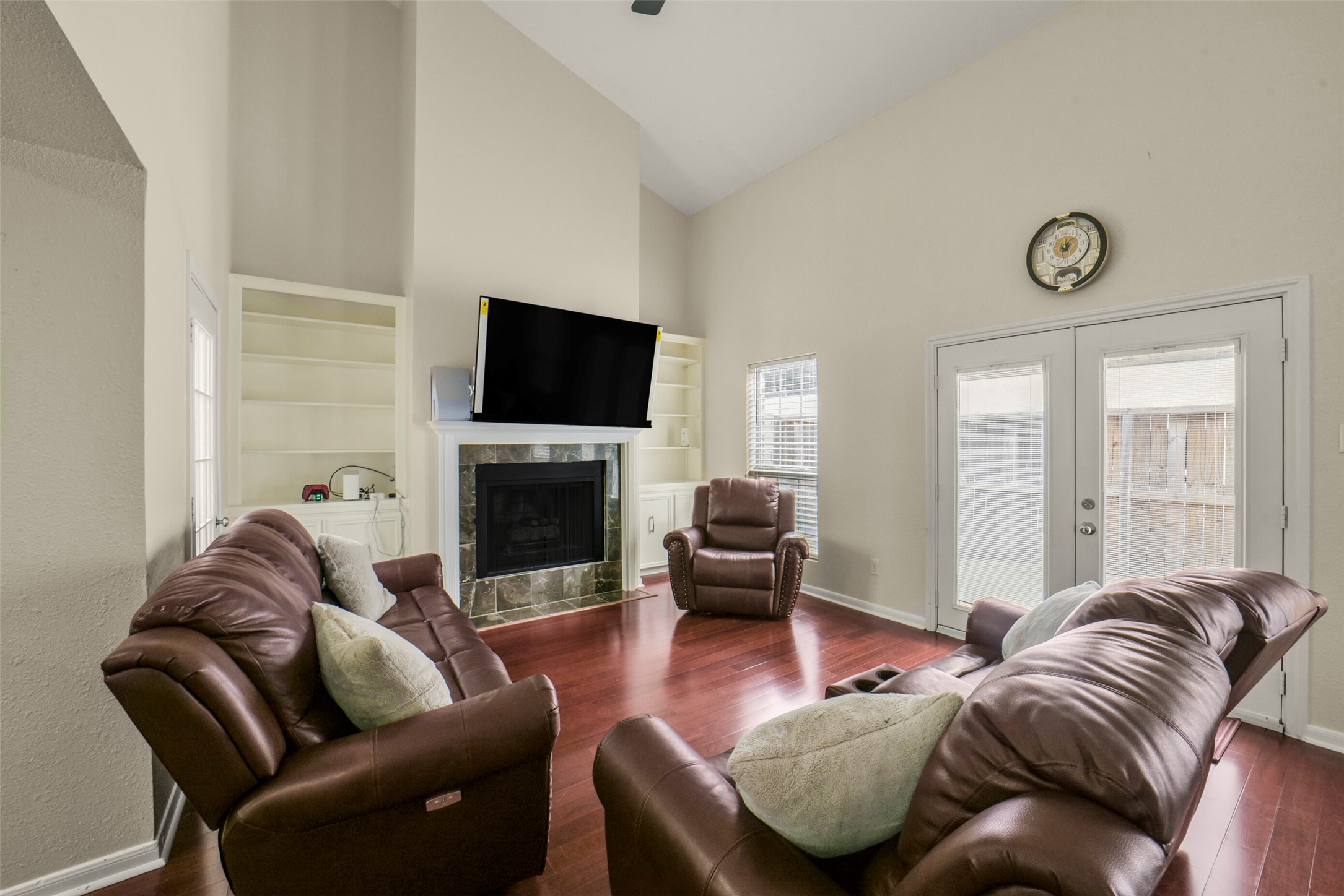 5707 Innsbruck Street Bellaire, TX 77401 - Photo 15 of 35 Large living area with fireplace and built-in cabinets with bookshelves. Vaulted ceilings give it a very spacious feel.
