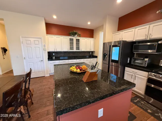 a view of kitchen with wooden floor and electronic appliances