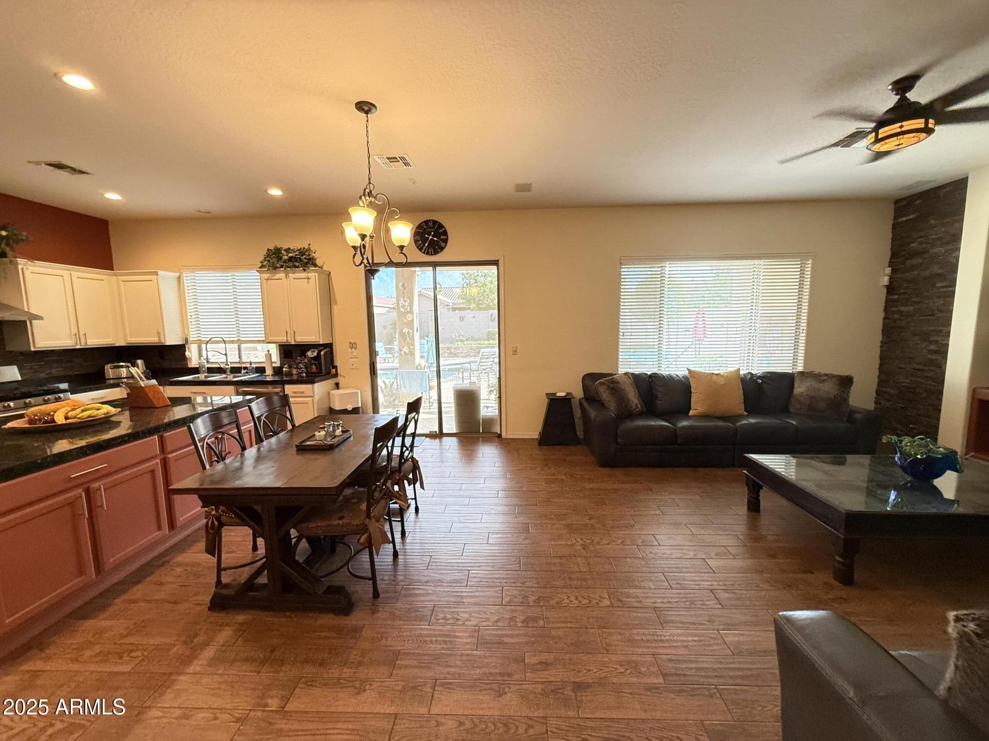 2245 West Clearview Trail Phoenix, AZ 85086 - Photo 76 of 76 a living room with furniture a fireplace and a dining table with wooden floor