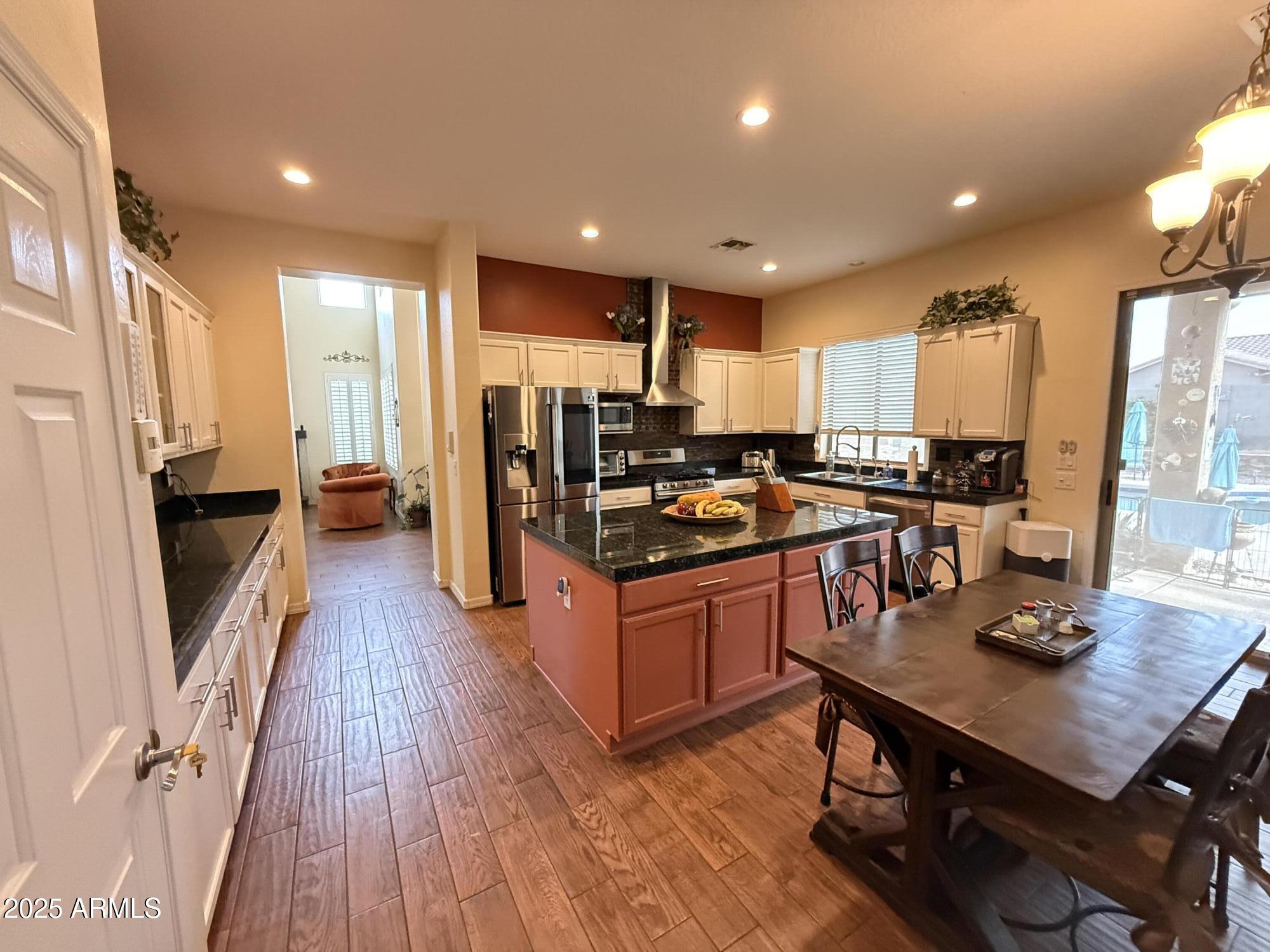2245 West Clearview Trail Phoenix, AZ 85086 - Photo 24 of 76 a kitchen with stainless steel appliances granite countertop a refrigerator a stove top oven a sink dishwasher and wooden cabinets with wooden floor