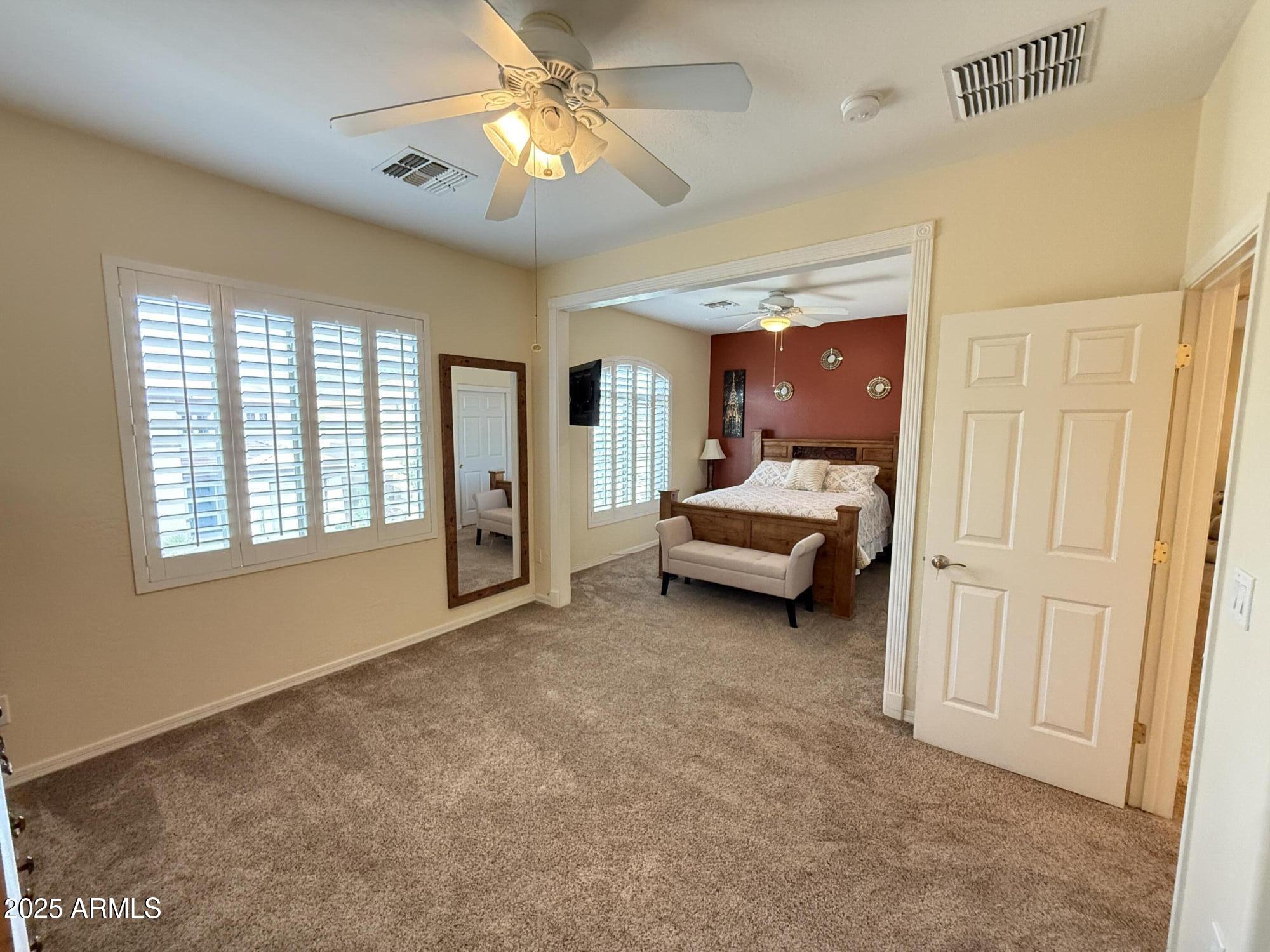 2245 West Clearview Trail Phoenix, AZ 85086 - Photo 47 of 76 a spacious bedroom with a bed and a chandelier