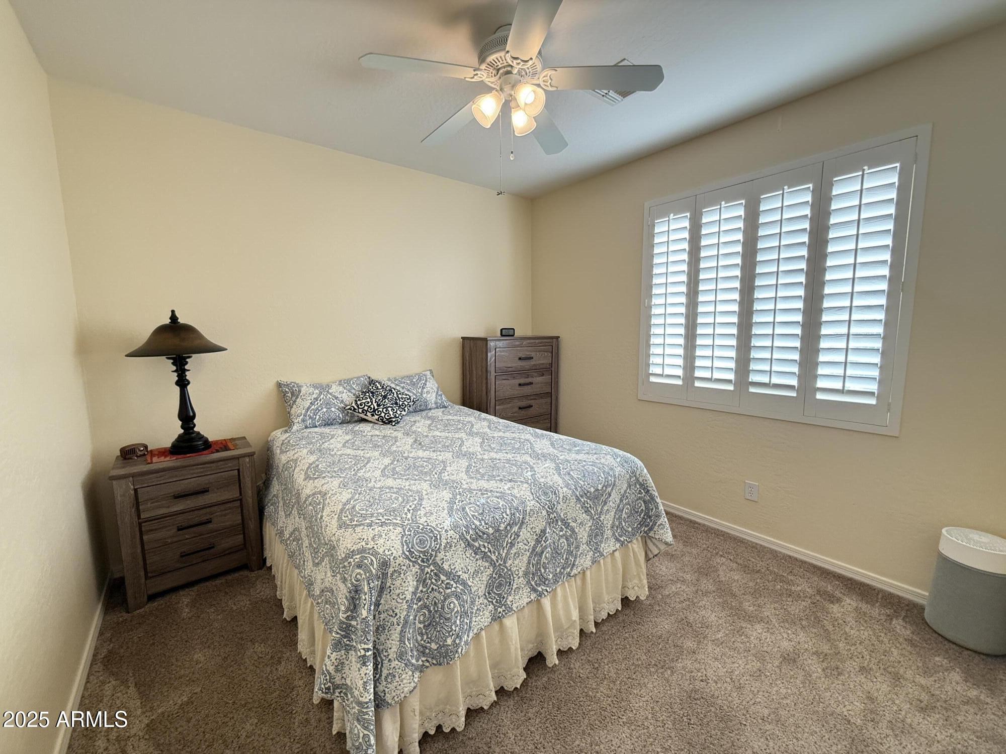 2245 West Clearview Trail Phoenix, AZ 85086 - Photo 55 of 76 a bed sitting in a bedroom next to a window and a chandelier