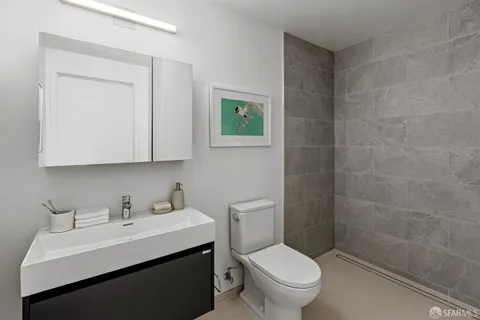 a bathroom with a sink a toilet and a mirror