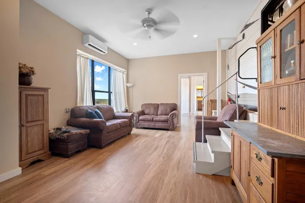 a living room with furniture a flat screen tv and a large window