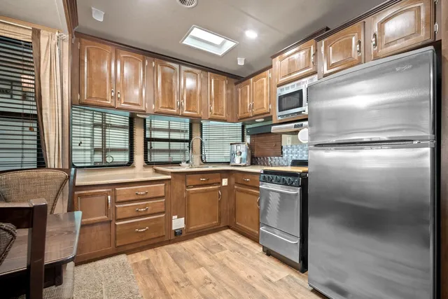 a view of living room kitchen with furniture and large windows