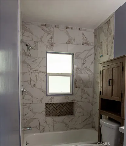 a bathroom with a toilet a sink and a window