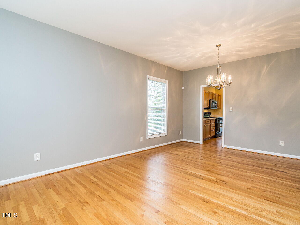 214 Competition Road Raleigh, NC 27603 - Photo 5 of 32 a view of an empty room with window and wooden floor