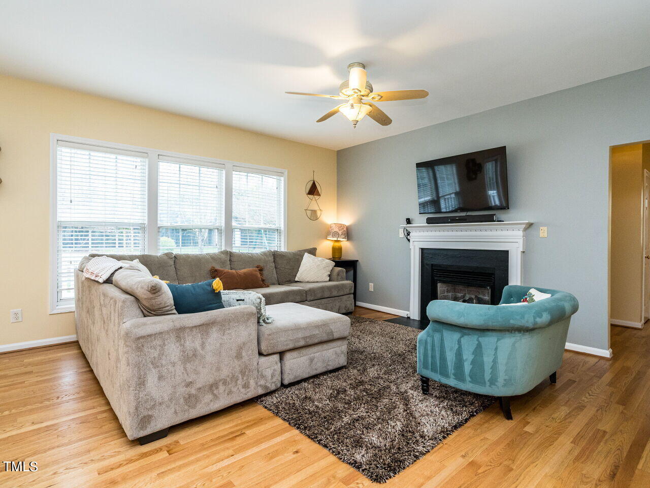 214 Competition Road Raleigh, NC 27603 - Photo 8 of 32 a living room with furniture a flat screen tv and a fireplace