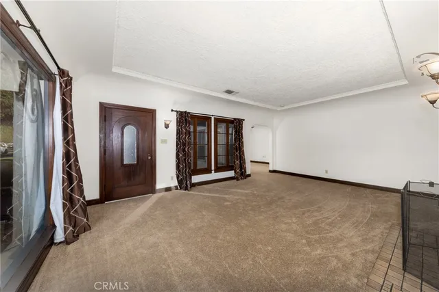 a view of an empty room with closet and a window