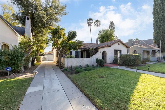 a view of a house with large tree plants and large trees