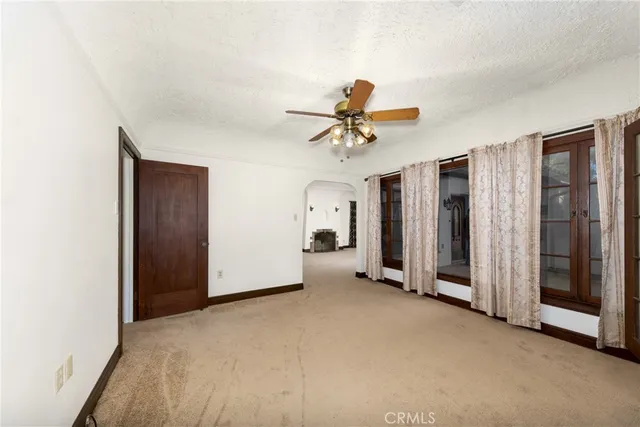 a view of a livingroom with a chandelier fan and a window