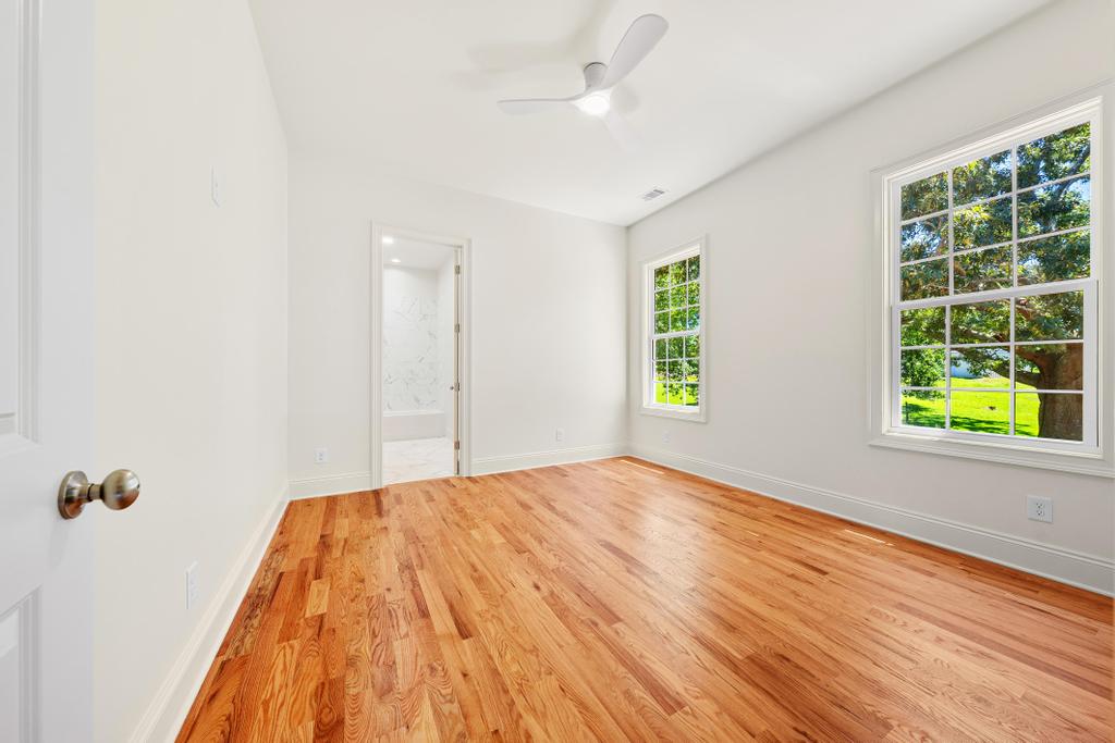 707 Vickery Street Extension Hartwell, GA 30643 - Photo 28 of 50 Hardwood floors and generous windows illuminate this inviting bedroom, with an en suite bathroom for comfort.